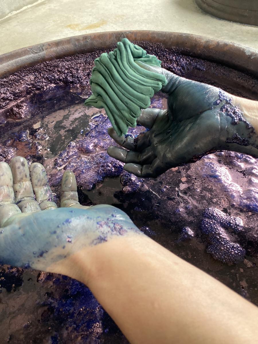 Dipping a folded fabric into the indigo bath