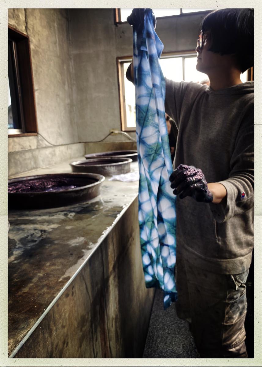 Chiharu unfolding her shibori after dipping in the indigo bath